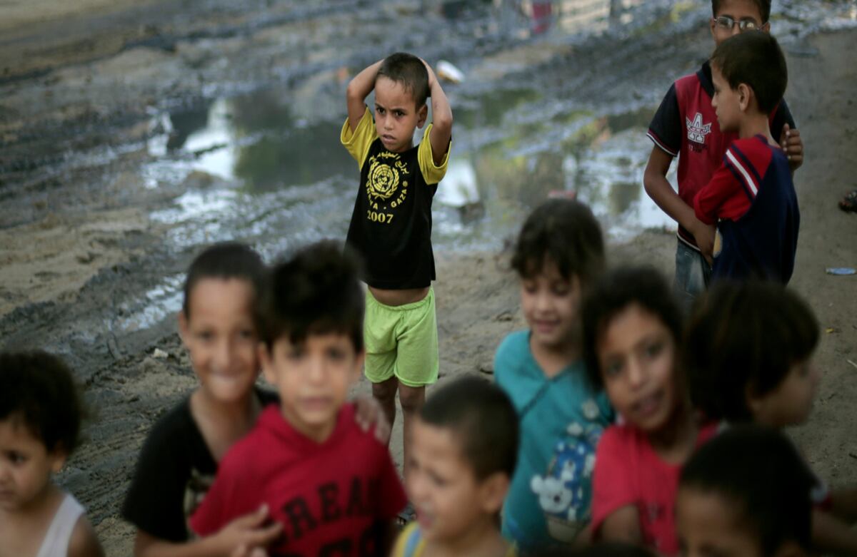 Niños palestinos juegan afuera de una escuela de las Naciones Unidas en la Franja de Gaza, donde viven luego de que sus hogares fueran destruidos por bombardeos israelíes. (AP)
