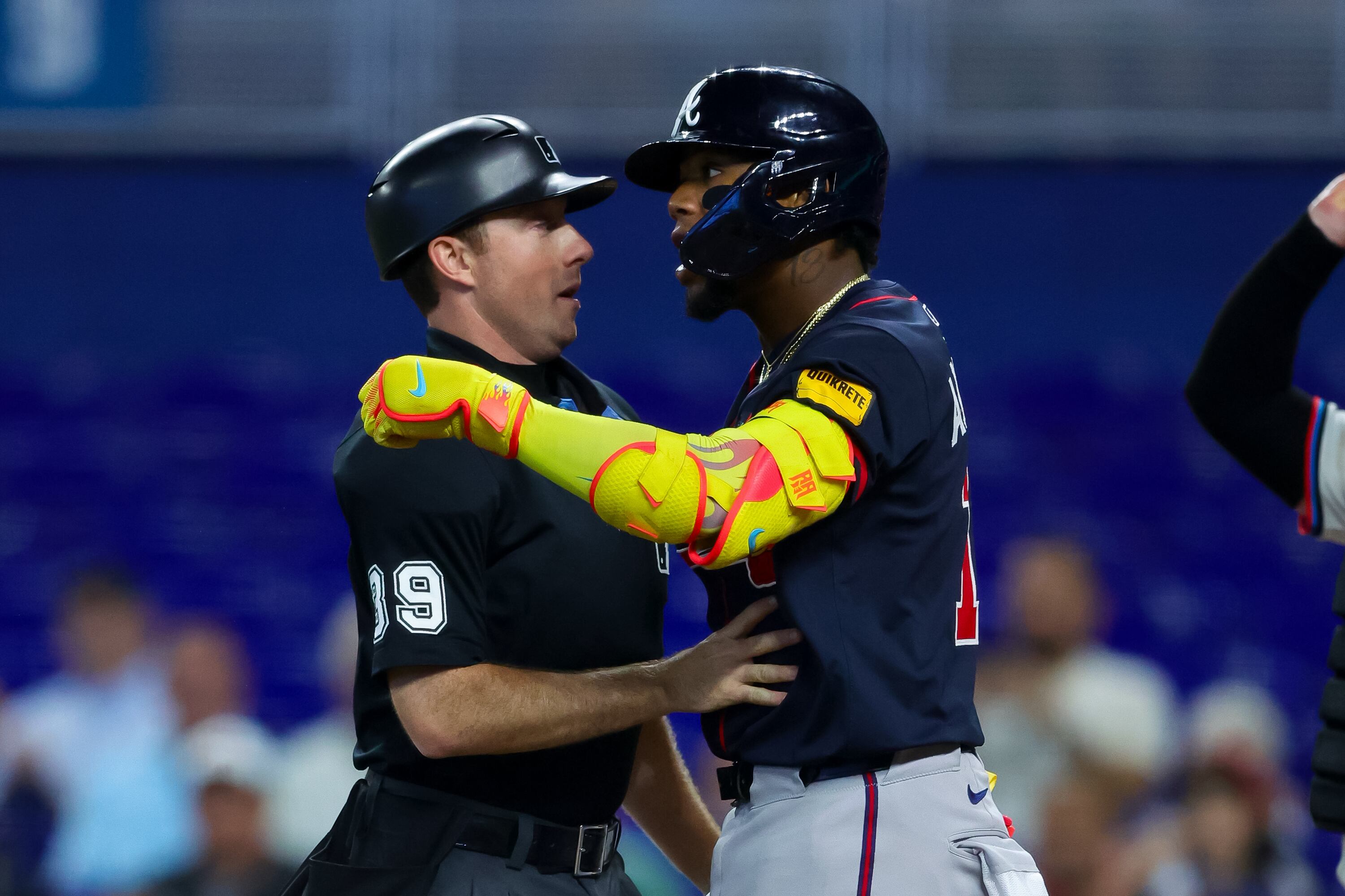 MIAMI, FLORIDA - AUGUST 27: Ronald Acuña Jr. #13 of the Atlanta Braves is held back by umpire Paul Nauert #39 after getting hit by a pitch in the third inning against the Miami Marlins at loanDepot park on August 27, 2025 in Miami, Florida. (Photo by Kelly Gavin/Getty Images)