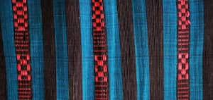 Las mujeres cortan las bolsas plásticas en tiras que sirven para tejer finas telas.