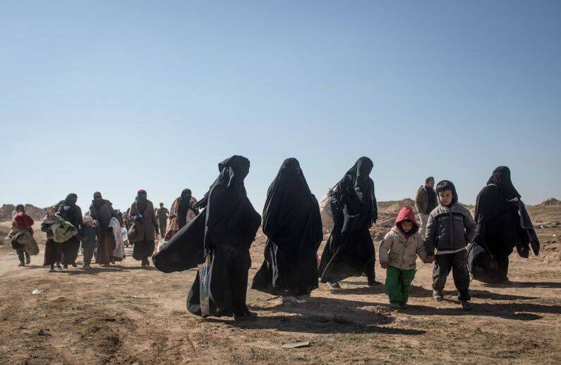 BAGOUZ, SIRIA - 12 DE FEBRERO: Más civiles esperan para abordar los camiones luego de ser examinados por miembros de las Fuerzas Democráticas de Siria (SDF) FOTO: Chris McGrath / Getty Images