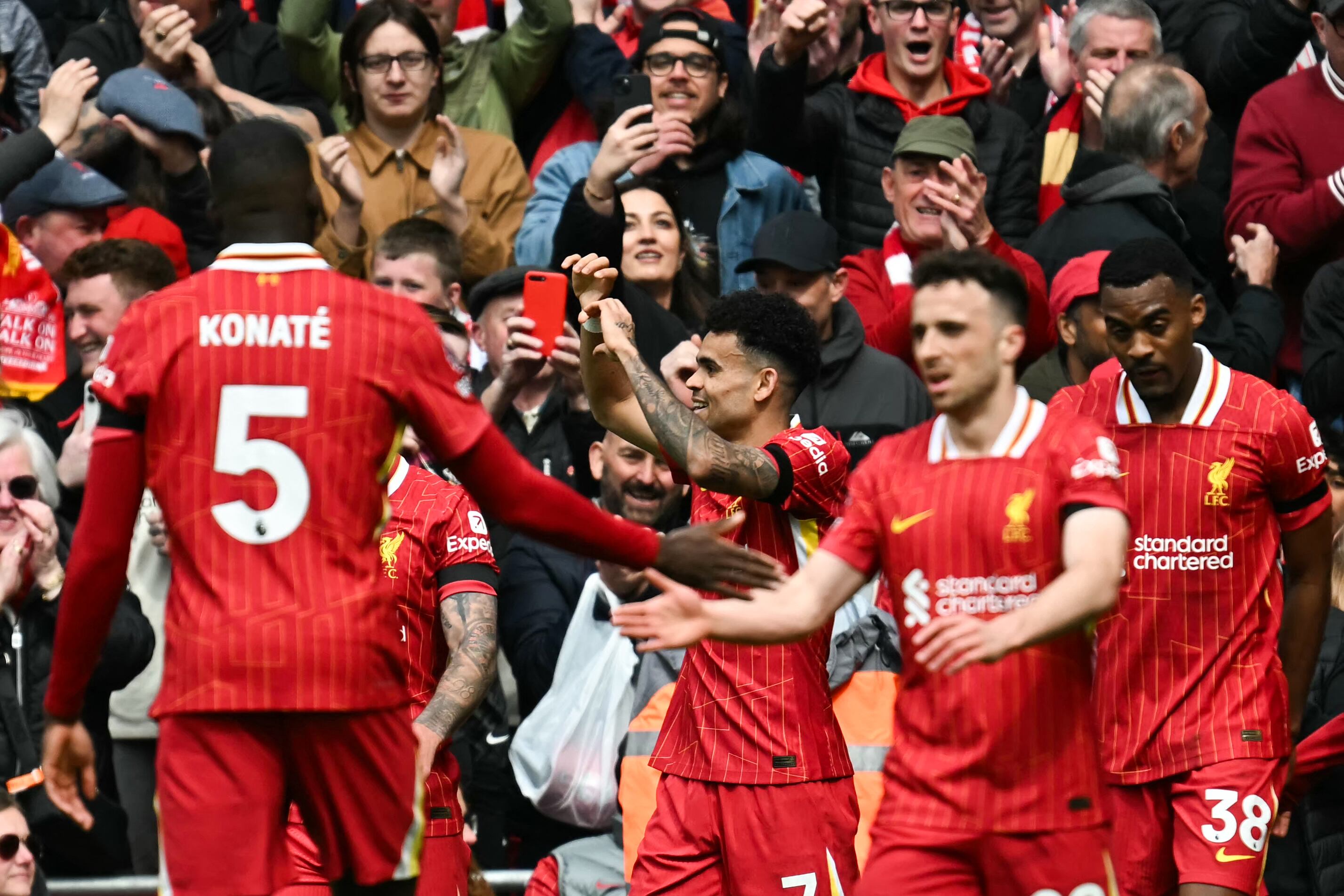 Liverpool's Colombian midfielder #07 Luis Diaz (C) celebrates with teammates after scoring his team first goal during the English Premier League football match between Liverpool and West Ham United at Anfield in Liverpool, north west England on April 13, 2025. (Photo by Paul ELLIS / AFP) / RESTRICTED TO EDITORIAL USE. NO USE WITH UNAUTHORIZED AUDIO, VIDEO, DATA, FIXTURE LISTS, CLUB/LEAGUE LOGOS OR 'LIVE' SERVICES. ONLINE IN-MATCH USE LIMITED TO 120 IMAGES. AN ADDITIONAL 40 IMAGES MAY BE USED IN EXTRA TIME. NO VIDEO EMULATION. SOCIAL MEDIA IN-MATCH USE LIMITED TO 120 IMAGES. AN ADDITIONAL 40 IMAGES MAY BE USED IN EXTRA TIME. NO USE IN BETTING PUBLICATIONS, GAMES OR SINGLE CLUB/LEAGUE/PLAYER PUBLICATIONS. /