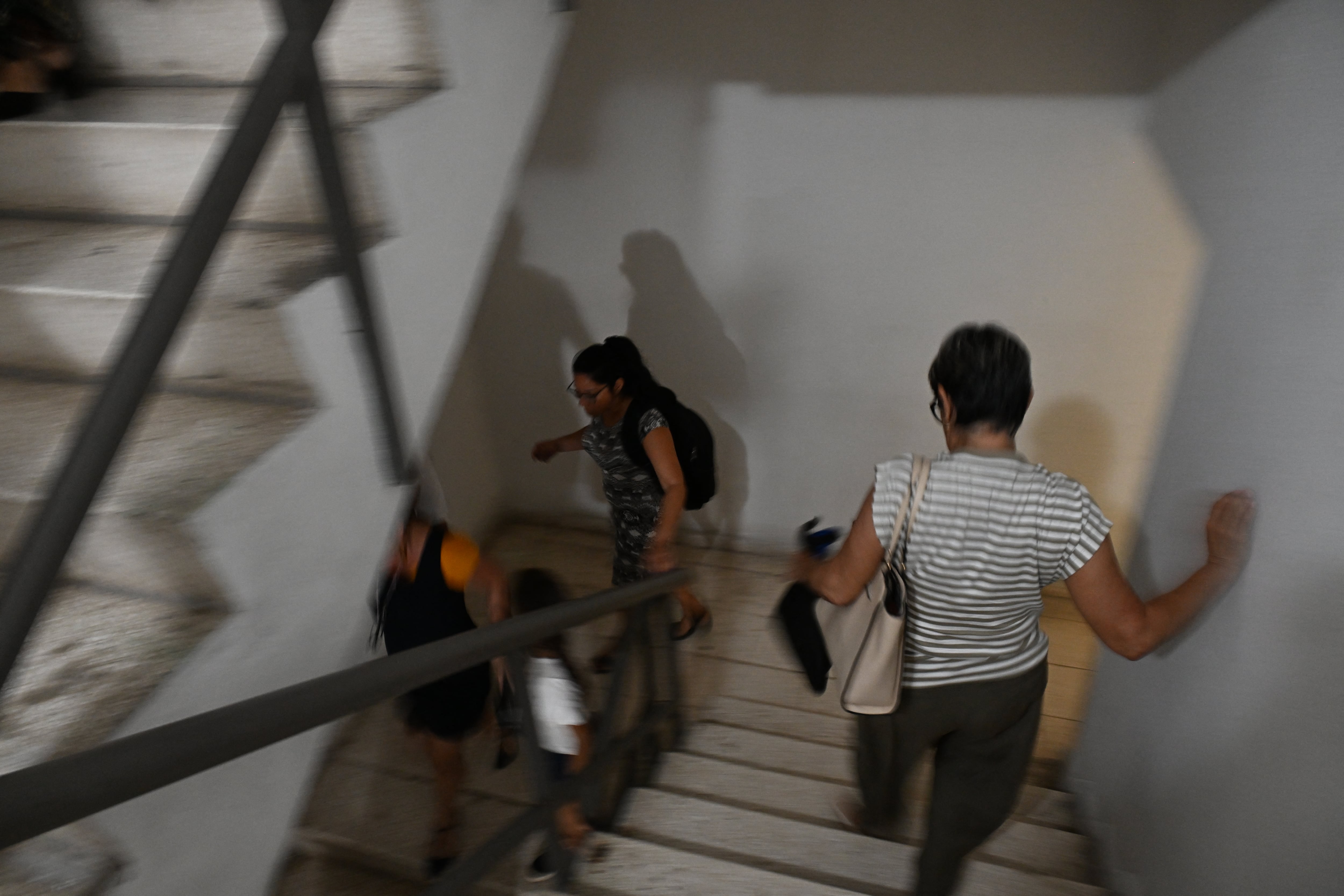 Trabajadores bajan corriendo las escaleras tras un temblor provocado por un terremoto de magnitud 6,5 en La Habana, el 8 de junio de 2026. Un fuerte terremoto sacudió la costa occidental de Cuba el 8 de junio de 2026. Periodistas de la AFP en La Habana informaron de 20 segundos de temblor que obligaron a los cubanos a salir de los edificios a las calles. El Servicio Geológico de Estados Unidos informó que el sismo tuvo una magnitud de 6,1 y se produjo a unos 100 kilómetros (62 millas) de la punta occidental de la isla. (Foto de YAMIL LAGE / AFP)