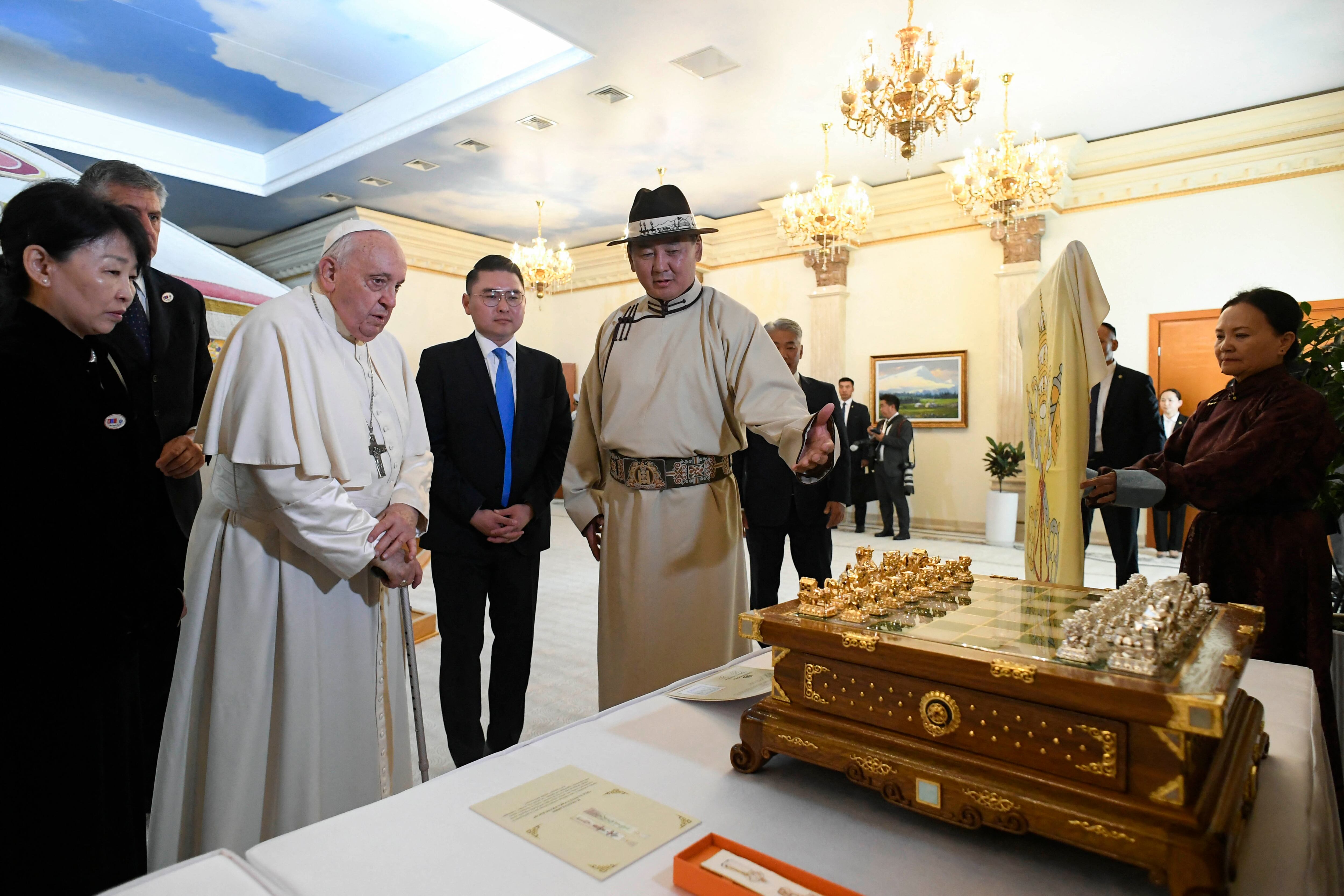 El presidente Ukhnaa Khurelsukh, luciendo una túnica tradicional, descendió por una larga escalinata decorada con una alfombra roja para recibir al papa justo enfrente de una enorme estatua de bronce de Gengis Kan.
