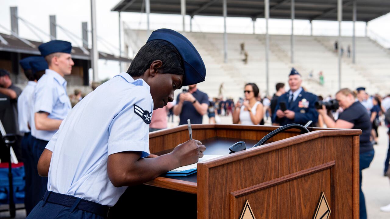 La aviadora de primera clase D'elbrah Assamoi, de Costa de Marfil, firma su certificado de ciudadanía estadounidense
