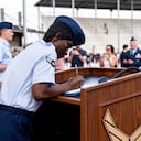 La aviadora de primera clase D'elbrah Assamoi, de Costa de Marfil, firma su certificado de ciudadanía estadounidense al final de una ceremonia de entrenamiento militar básico en la Base Conjunta San Antonio-Lackland, el 26 de abril de 2023, en San Antonio, Texas. (Vanessa R. Adame/Fuerza Aérea de Estados Unidos vía AP)