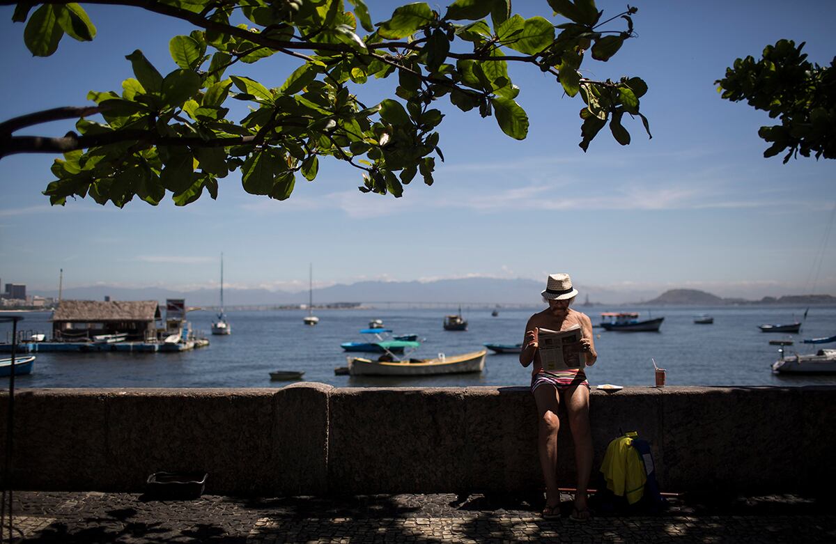 Un hombre lee un periódico en el barrio Urca en Río de Janeiro, Brasil. (AP)