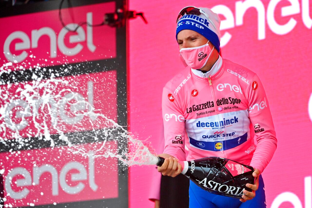 Overall leader, Portugal's Joao Almeida celebrates on the podium at the end of the third stage of the Giro d'Italia, tour of Italy cycling race from Enna to Etna, Sicily, Monday, Oct. 5, 2020. (Gian Mattia D'Alberto/LaPresse via AP)