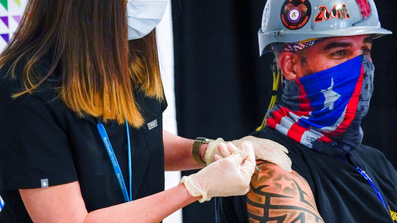 CORRECTS SPELLING TO NORTHWELL FROM NORTHEWEL - A Northwell Health nurse inoculates Local 28 Sheet Metal Worker Demetrius Buttelman with the first dose of the Pfizer vaccine during a news conference, Wednesday, April 14, 2021 at the Belmont Park in Elmont, N.Y. Many of the construction workers working at the USB Arena will be vaccinated at the Belmont Park pop up vaccination site. (AP Photo/Mary Altaffer, Pool)