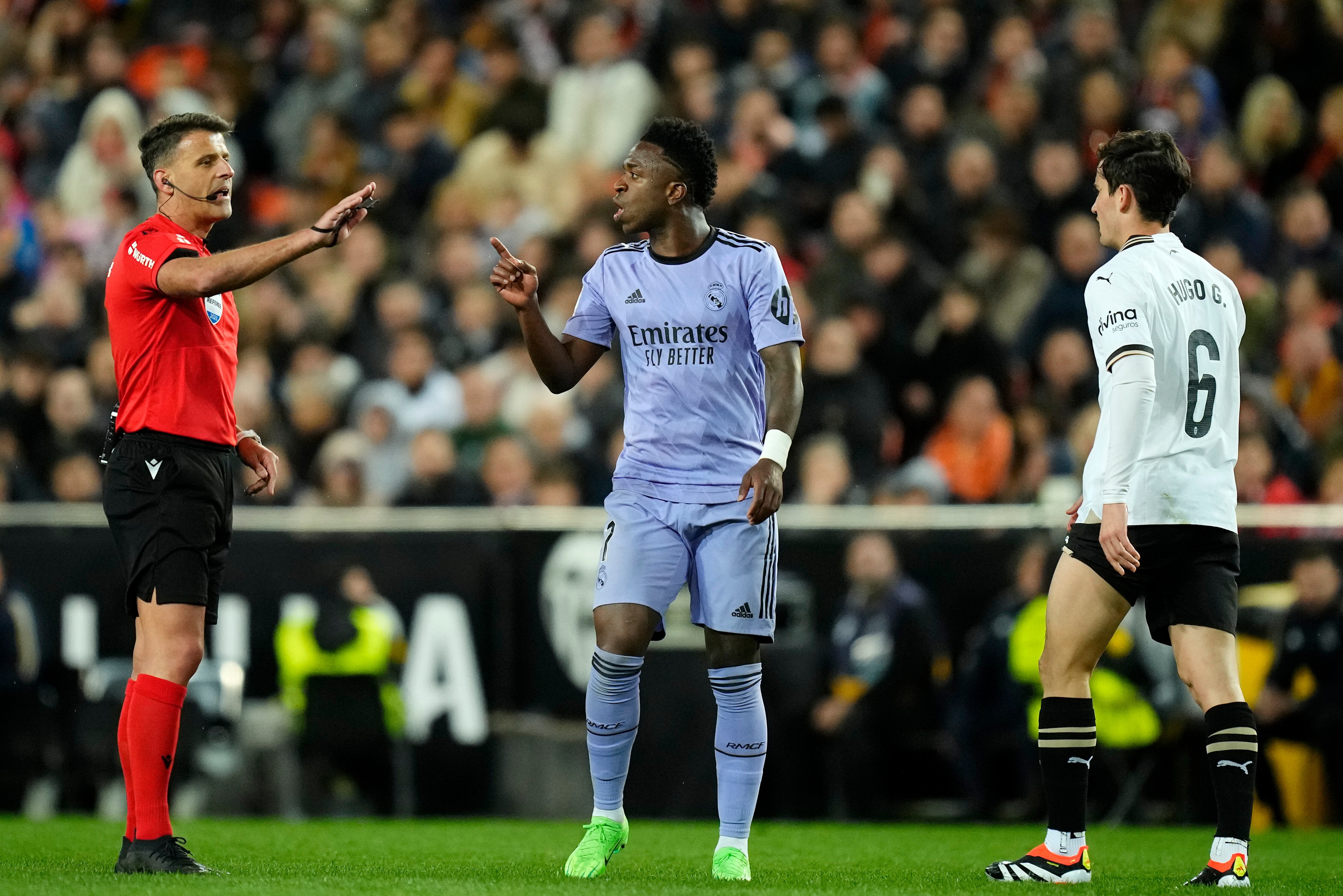 Vinicius Junior del Real Madrid hace gestos mientras habla con el árbitro Gil Manzano durante el partido de fútbol de La Liga entre Valencia y Real Madrid en el Estadio Mestalla en Valencia, España, el sábado 2 de marzo de 2024. (Foto AP/José Bretón)