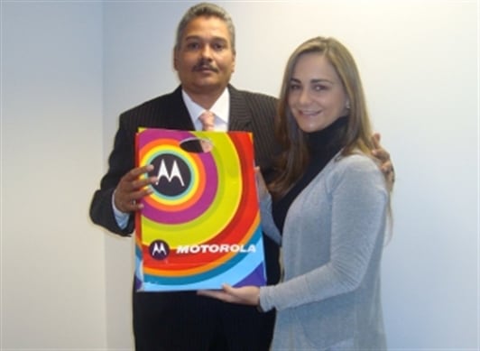 Gina Acosta, Gerente de Comunicaciones Externas de Latinoamérica Norte de Motorola, hace entrega del equipo A45 Eco a Gerardo de Armas.