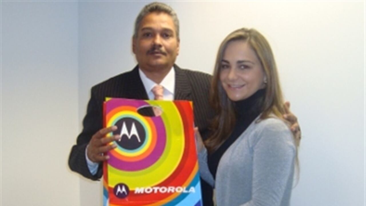 Gina Acosta, Gerente de Comunicaciones Externas de Latinoamérica Norte de Motorola, hace entrega del equipo A45 Eco a Gerardo de Armas.