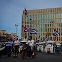 Varias personas pasan en vehículos eléctricos frente a la embajada de Estados Unidos durante una marcha juvenil antiimperialista organizada por el gobierno en La Habana, Cuba.