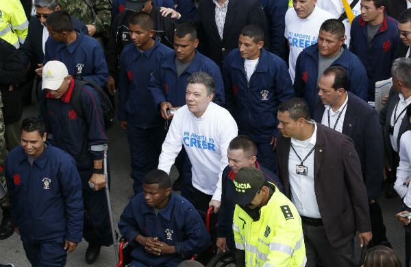 Durante su recorrido desde el monumento a los Héroes Caídos hasta el Centro de Memoria Histórica, el presidente Santos acompañó a un miembro de la Fuerza Pública herido en combate. Fotografía: Guillermo Torres / SEMANA.