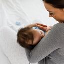 Joven madre amamantando a su pequeño bebé