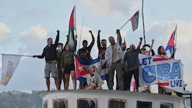 Activistas ondean banderas cubanas y palestinas desde el buque Maguro, que llega procedente de México con ayuda humanitaria como parte del convoy "Nuestra América".