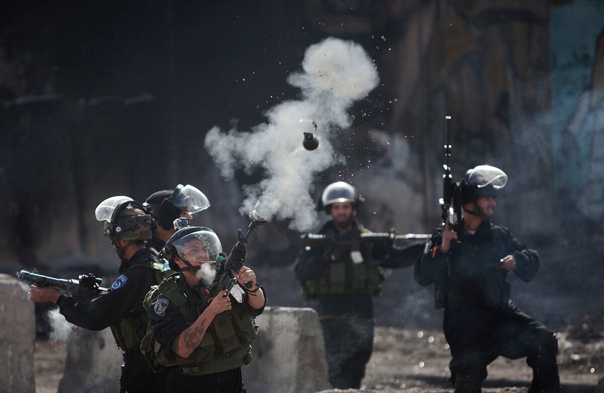 Un policía de fronteras israelí dispara un cilindro de gas lacrimógeno a protestantes palestinos, durante enfrentamientos que ocurrieron por la postura de Israel frente a los creyentes que visitan la mezquita Al-Aqsa, en Ramallah. (AP)