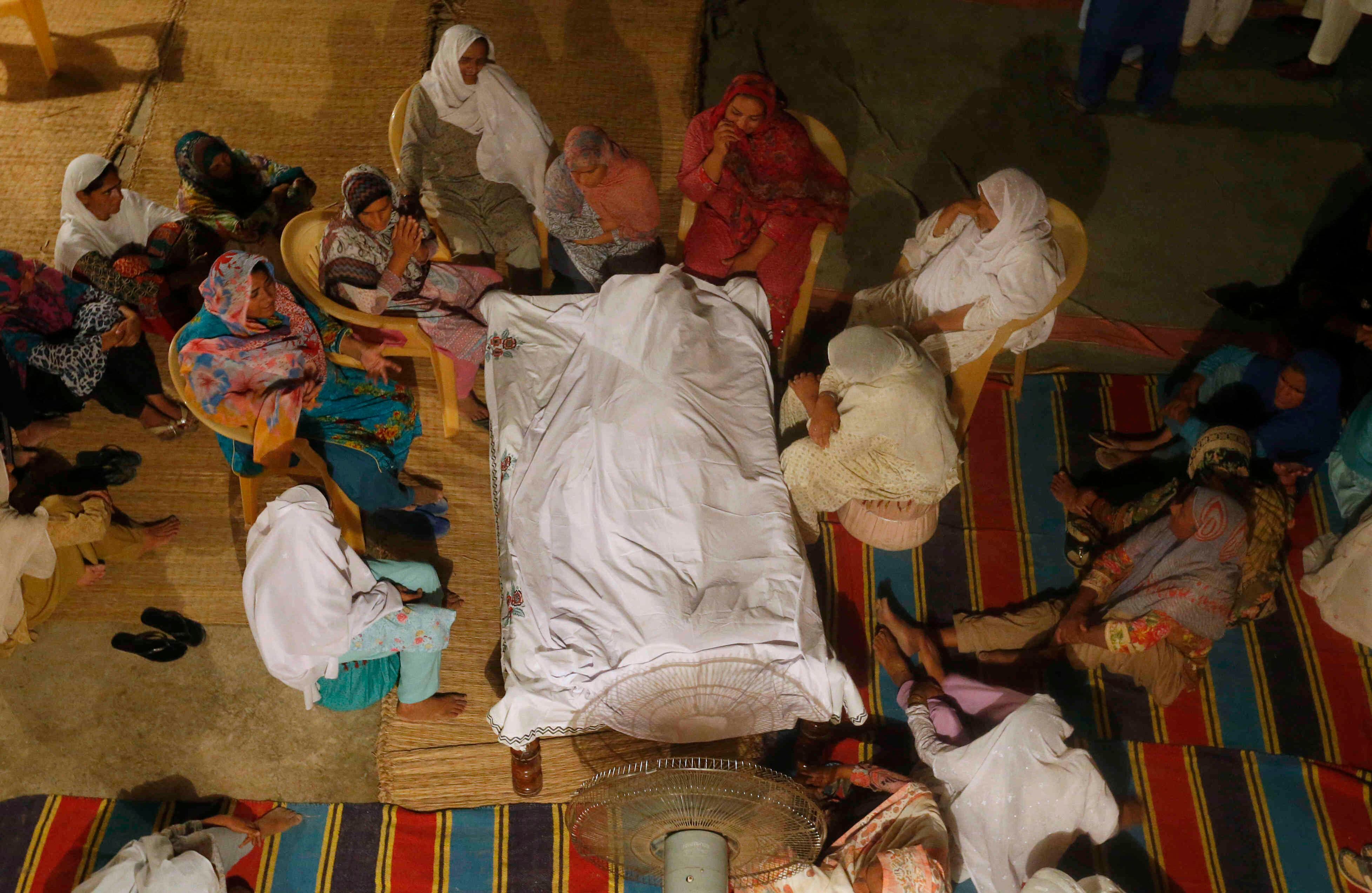 Las mujeres lloran, como es tradición en la cultura musulmana pakistaní, alrededor del cuerpo de uno de sus familiares, quien murió al colapsar su casa por el terremoto. Foto: AP/ ANJUM NAVEED.