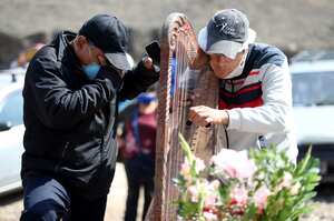 LIMA, PERÚ - 02 DE JUNIO: Familiares de Rosa Berrocal, de 33 años, tocan música con el arpa y lloran frente a su ataúd en la sección del cementerio Nueva Esperanza reservada para casos de COVID-19 el 2 de junio de 2020 en Villa María del Triunfo, Lima, Perú. (Foto de Raul Sifuentes / Getty Images)