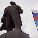 Pro-rusos izan la bandera de Ucrania y Rusia al lado de una estatua de Stalin.