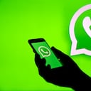 PARÍS, FRANCIA - 10 DE DICIEMBRE: En esta ilustración fotográfica, el logotipo de WhatsApp se muestra en la pantalla de un iPhone frente a una pantalla de TV que muestra el logotipo de WhatsApp el 10 de diciembre de 2019 en París, Francia. El servicio de mensajería instantánea WhatsApp dejará de funcionar en millones de teléfonos en los próximos meses, ya que la empresa retira el soporte para algunas plataformas móviles más antiguas. A partir del 1 de febrero de 2020, ya no se admitirá ningún iPhone con iOS 8 o anterior, ni ningún dispositivo Android con la versión 2.3.7 o anterior. (Foto de Chesnot/Getty Images)