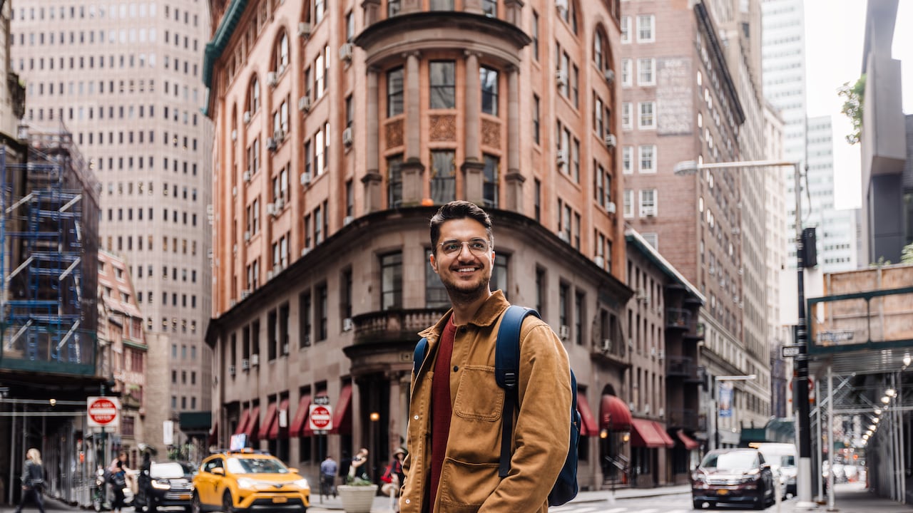 Hombre feliz y sonriente en las calles del centro de Manhattan, Nueva York, EE. UU.