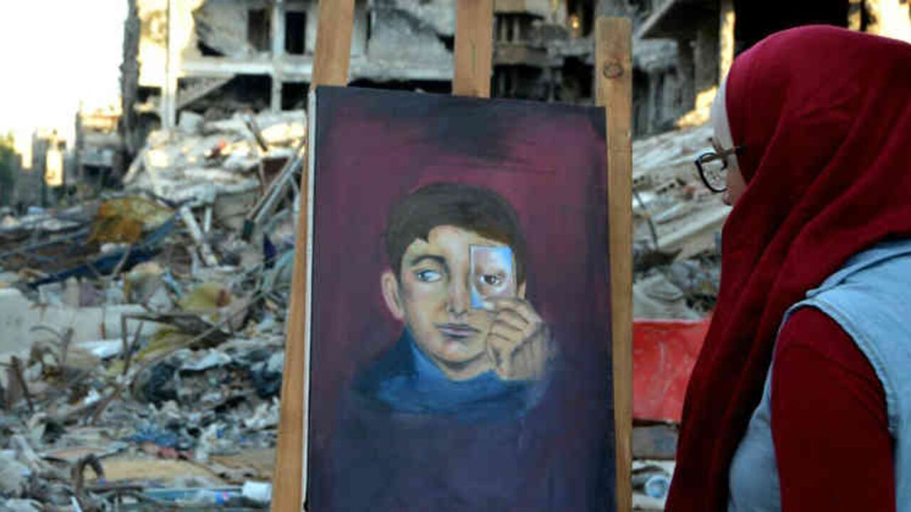 Cuadro pintado por Hinaya Kibabi entre las ruinas del barrio de Yarmuk, en Damasco, el 15 de agosto de 2018. Foto: AFP | Masher Al Mounes.
