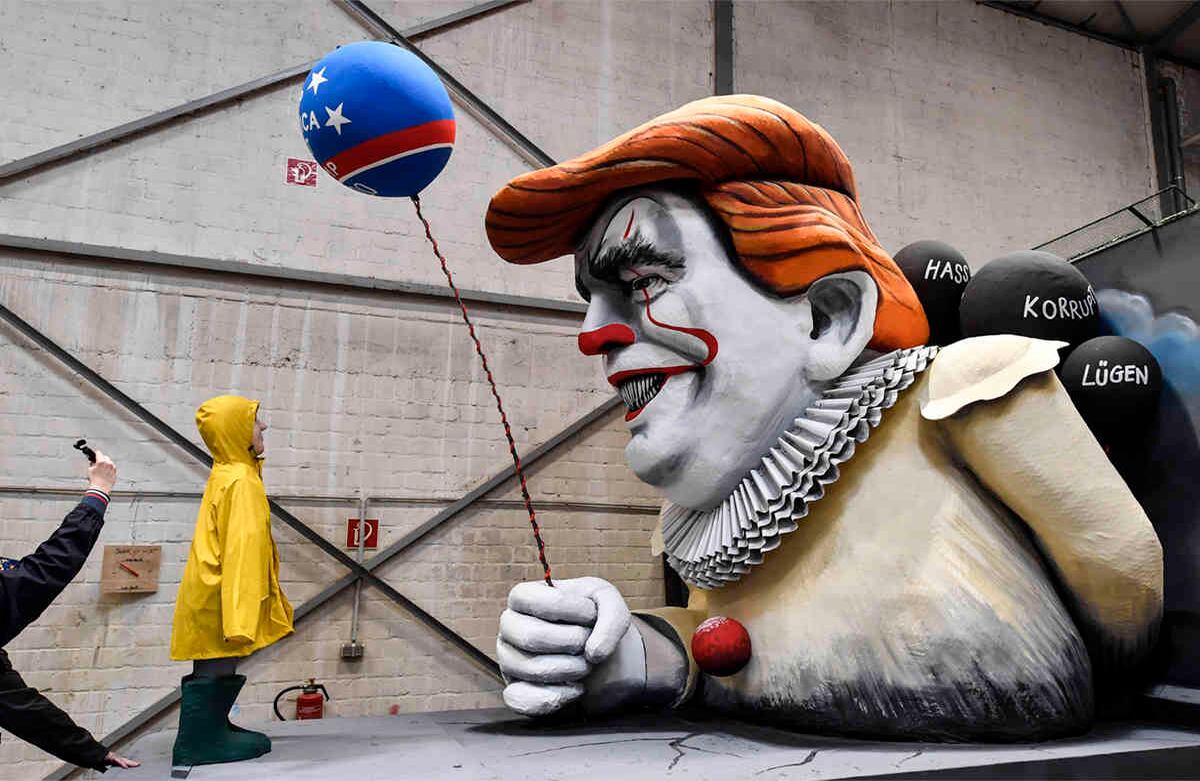Un hombre toma una foto de una carroza de carnaval satírica, que representa al Presidente de los Estados Unidos Donald Trump como el payaso de terror Pennywise durante un preestreno en un salón en Colonia, Alemania, el 18 de febrero de  2020. Los tradicionales desfiles de carnaval del Rose Monday se burlan de la política y son vistos por cientos de miles en las calles de Colonia, Düsseldorf y Maguncia. Foto: Martin Meissner/ AP. 