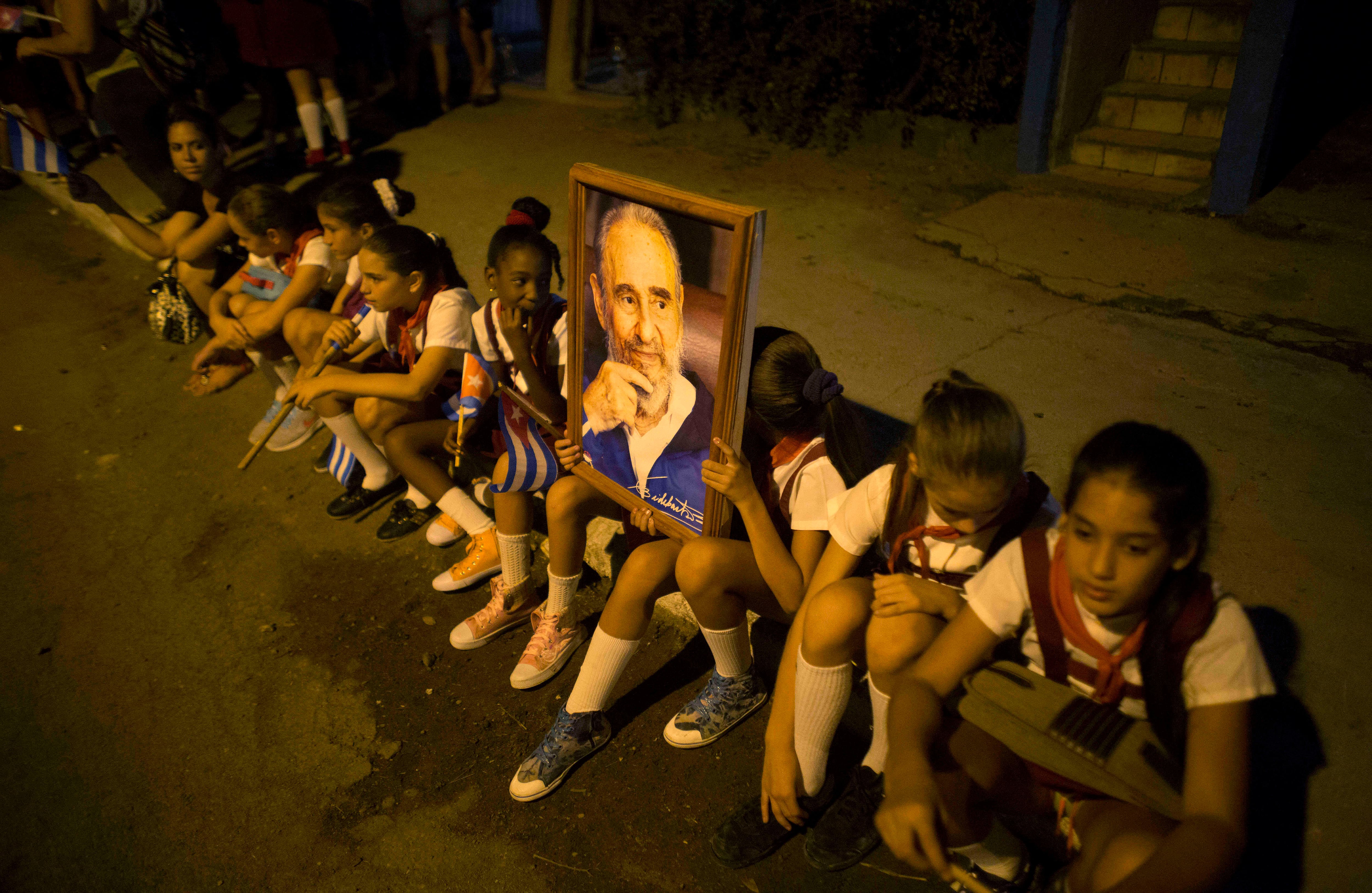 Niños de la escuela sostienen una imagen de Fidel Castro, mientras esperan el paso de la caravana que lleva las cenizas del líder político, (AP Photo/Dario Lopez-Mills)