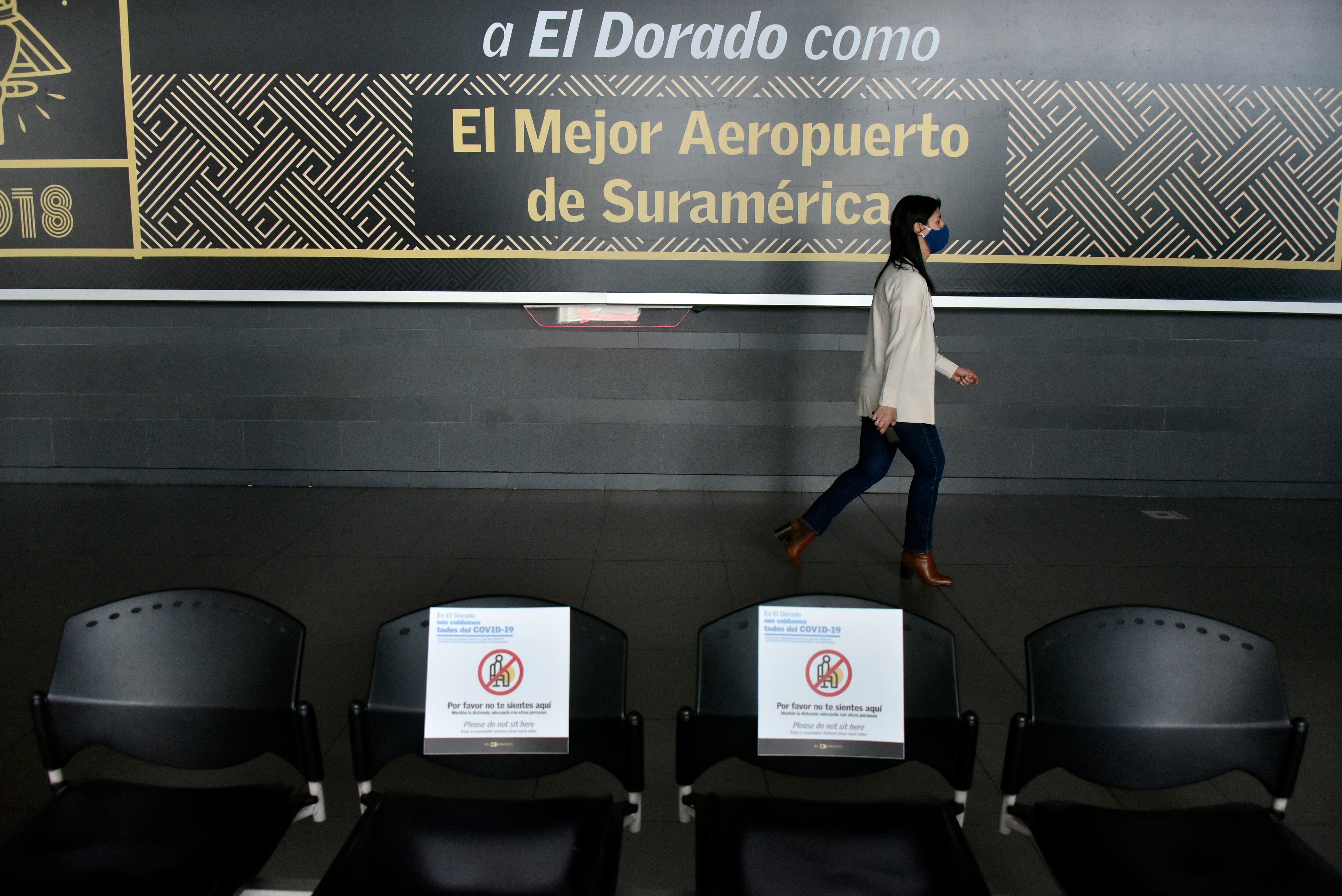 BOGOTA, COLOMBIA - AUGUST 31: A woman wearing a face mask walks down a hallway at El Dorado International Airport on August 31, 2020 in Bogota, Colombia. Bogota's international airport El Dorado received approval from the Airport Council International to resume activities after remaining closed due to COVID-19 pandemic since March 26. National government authorized national routes to restart operating from this week. (Photo by Guillermo Legaria/Getty Images)