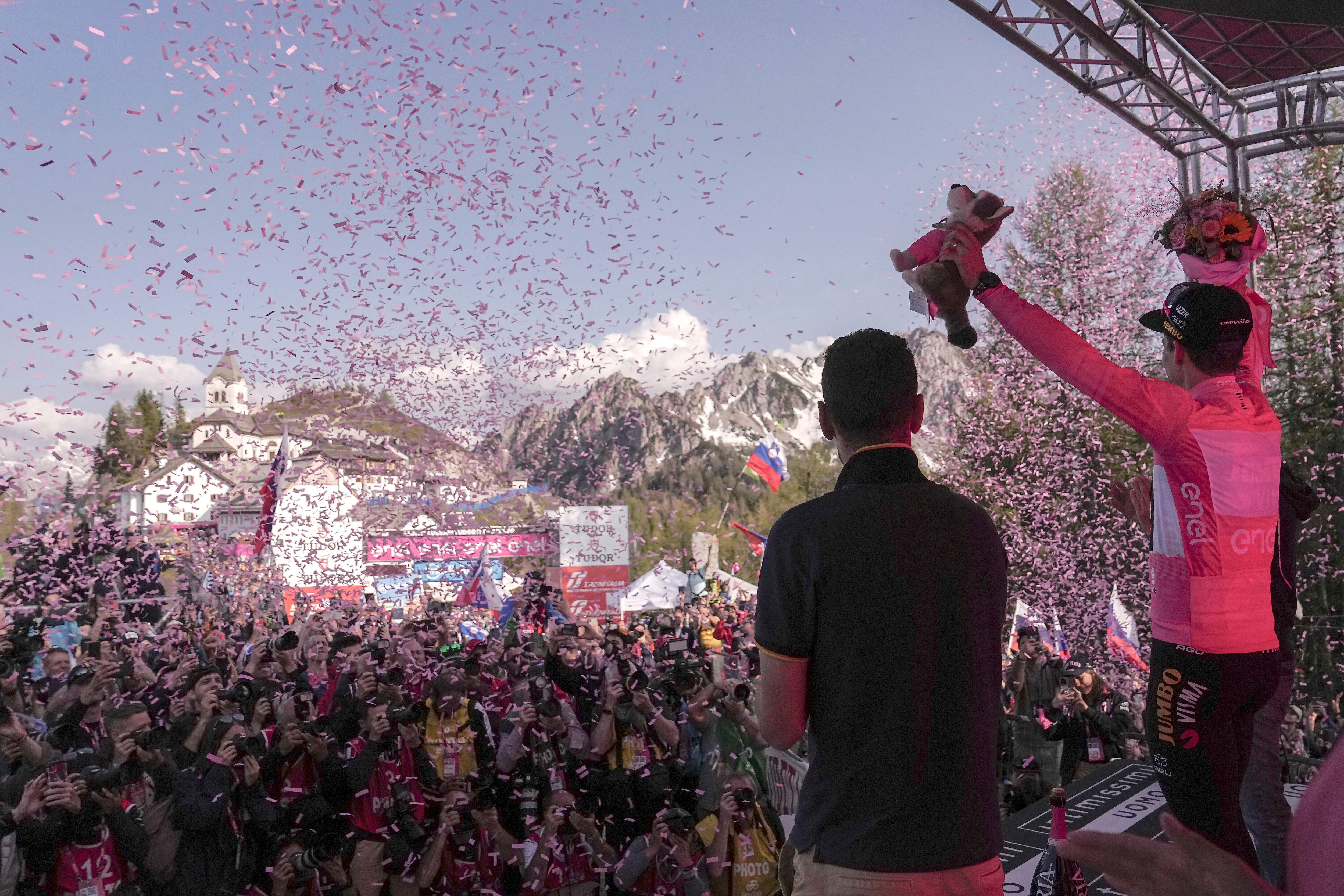 Slovenia's Primoz Roglic, right, wears the pink jersey of the overall leader as he celebrates on the podium at the end of the 20th stage of the Giro d'Italia cycling race, an individual mountain time trial from Tarvisio to Monte Lussari, Italy, Saturday, May 27, 2023. Roglic all but secured the Giro d’Italia title on Saturday by overtaking leader Geraint Thomas on the penultimate stage despite having a mechanical problem on the mountain time trial. (Marco Alpozzi/LaPresse via AP)