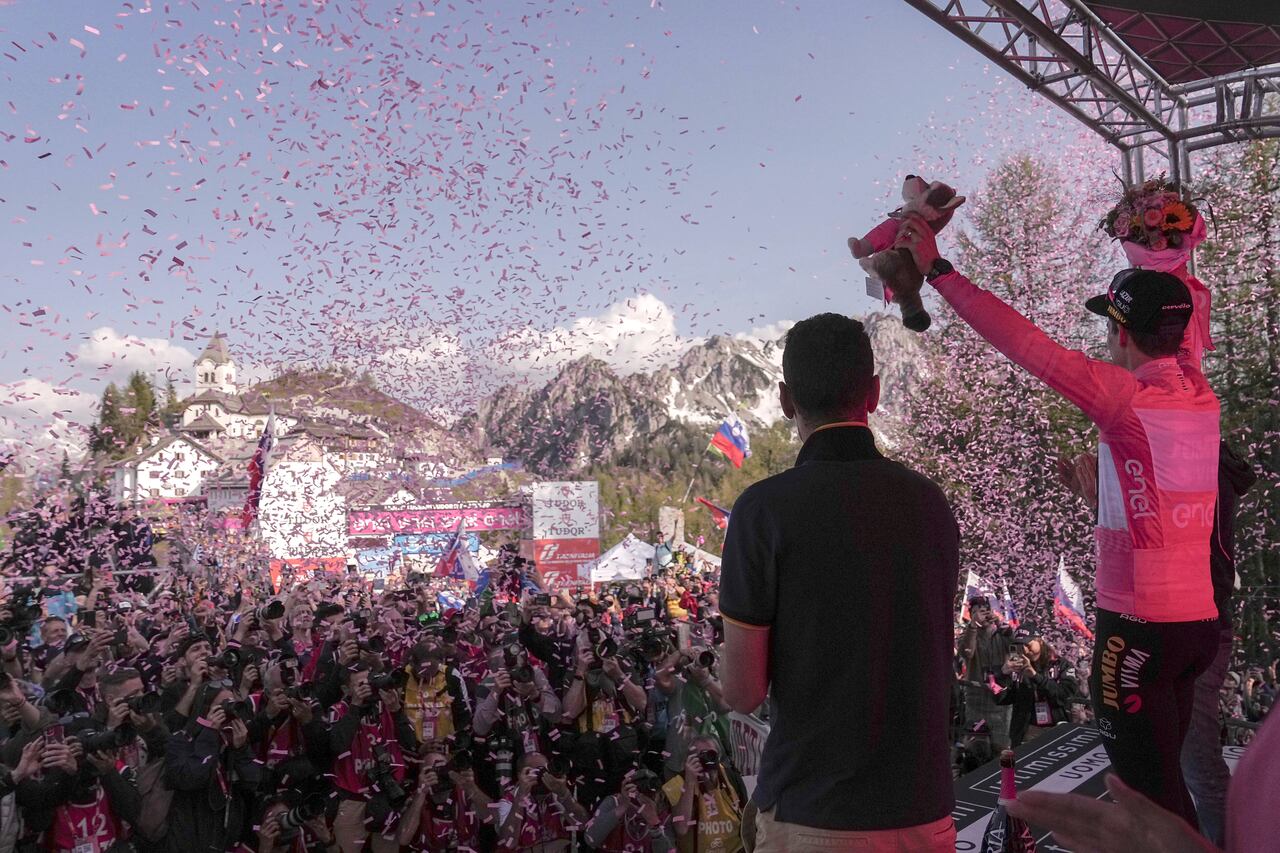 Slovenia's Primoz Roglic, right, wears the pink jersey of the overall leader as he celebrates on the podium at the end of the 20th stage of the Giro d'Italia cycling race, an individual mountain time trial from Tarvisio to Monte Lussari, Italy, Saturday, May 27, 2023. Roglic all but secured the Giro d’Italia title on Saturday by overtaking leader Geraint Thomas on the penultimate stage despite having a mechanical problem on the mountain time trial. (Marco Alpozzi/LaPresse via AP)