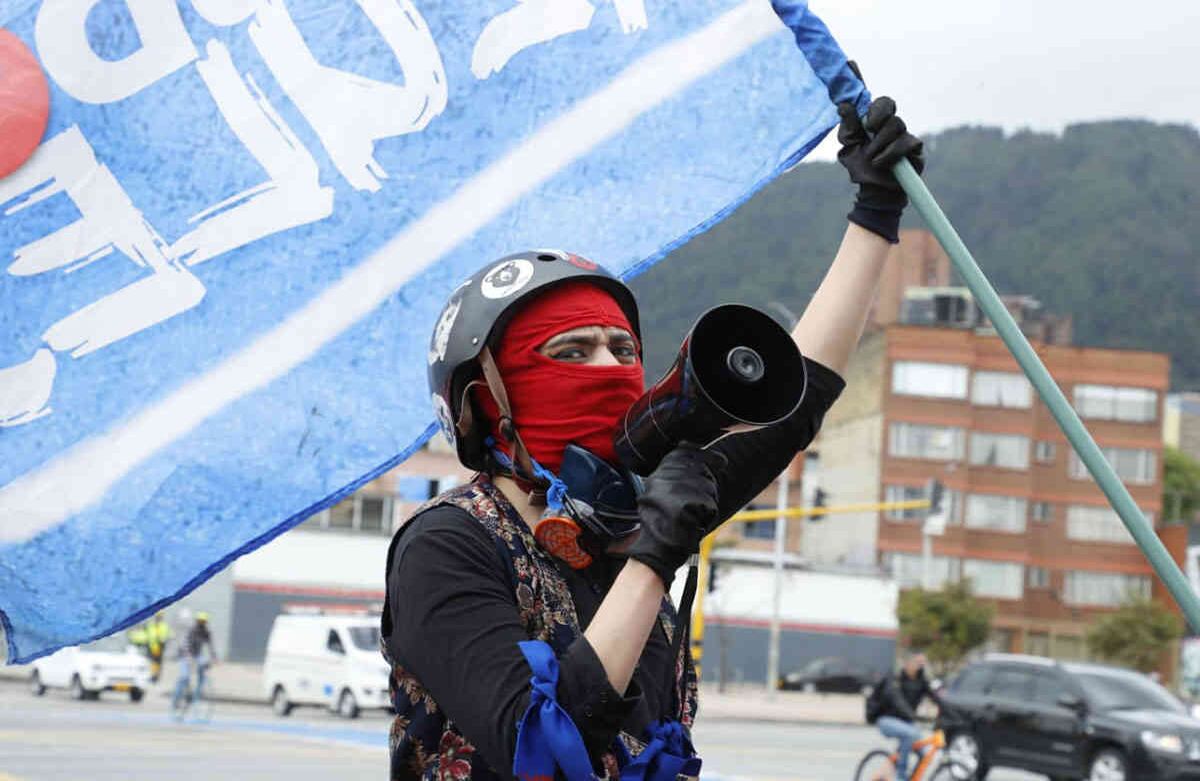 Un joven vestido de negro ondea una bandera protesta ante el aumento de las masacres en distintas regiones del país. Foto Guillermo Torres / Semana
