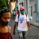 A man wearing a T-shirt with the US flag walks along a street of Havana, on May 17, 2022. - The United States said Monday it is easing restrictions imposed during former president Donald Trump's administration on travel to Cuba and on the sending of family remittances between the United States and the communist island. (Photo by YAMIL LAGE / AFP)