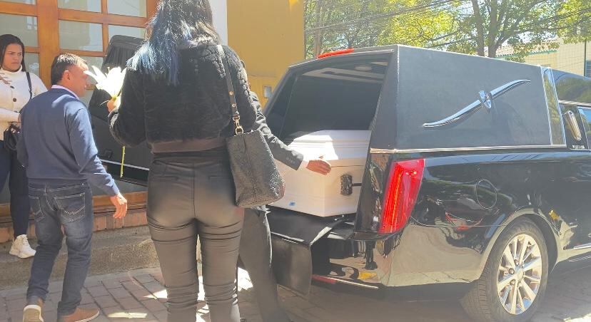 Los participes ayudando a subir el ataúd al coche fúnebre.