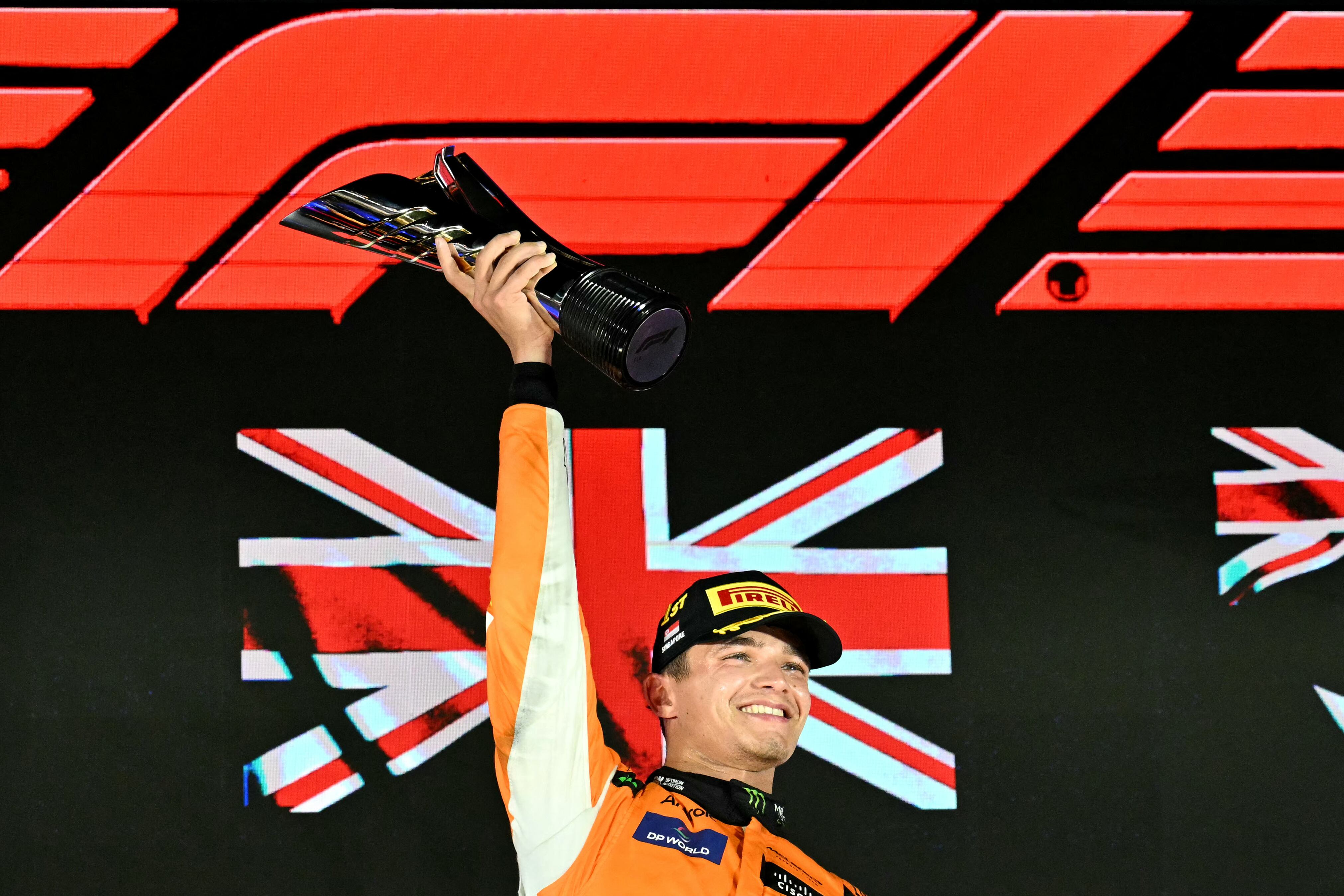 McLaren's British driver Lando Norris celebrates winning on the podium after the Formula One Singapore Grand Prix night race at the Marina Bay Street Circuit in Singapore on September 22, 2024. (Photo by MOHD RASFAN / AFP)