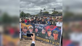 Director de la Policía, general William Rincón, posando con la pancarta de Defensores de la Patria.