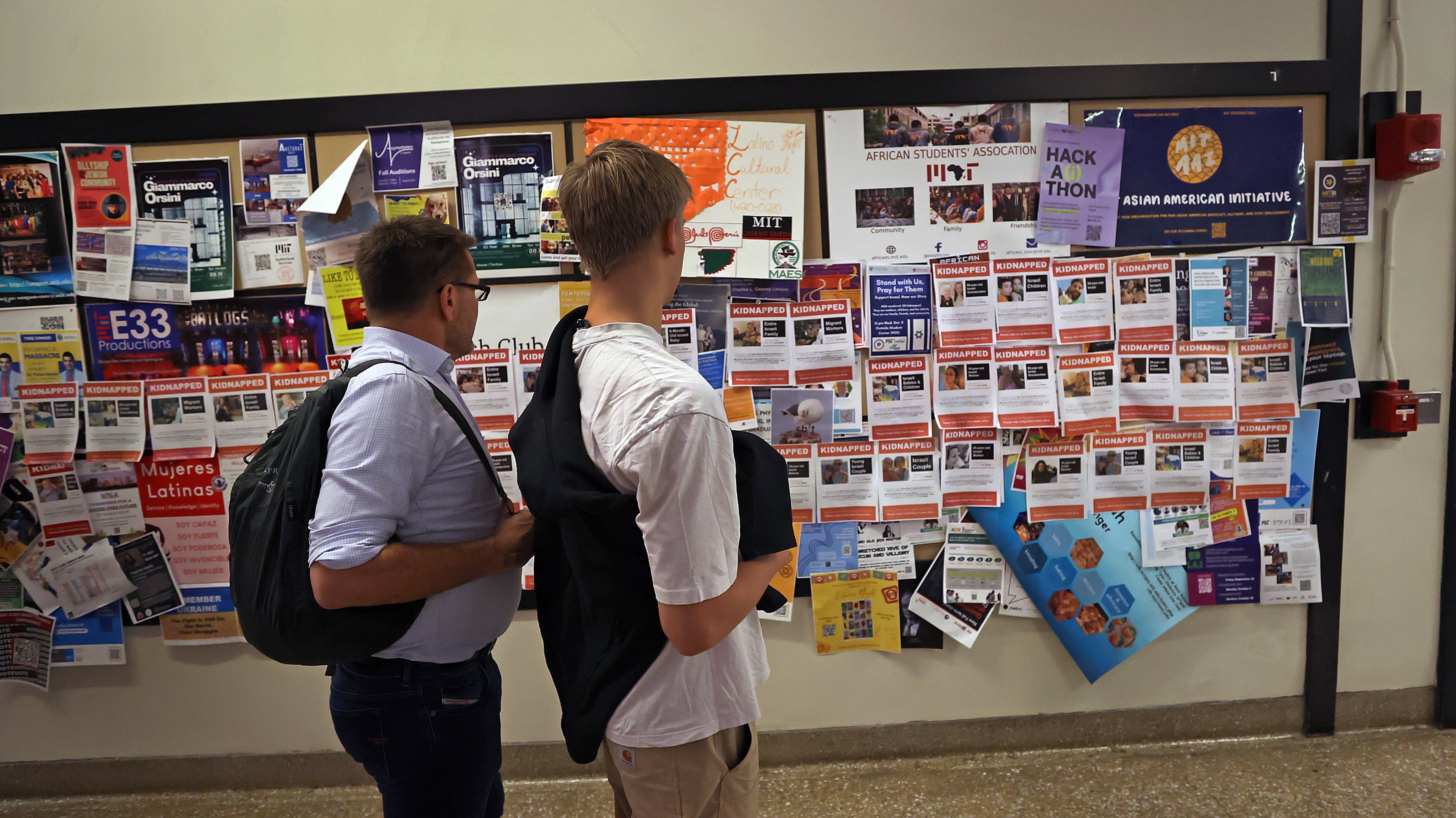 Dos estudiantes miran folletos en el campus del MIT que fueron publicados en respuesta a los ataques de Hamas en Israel.