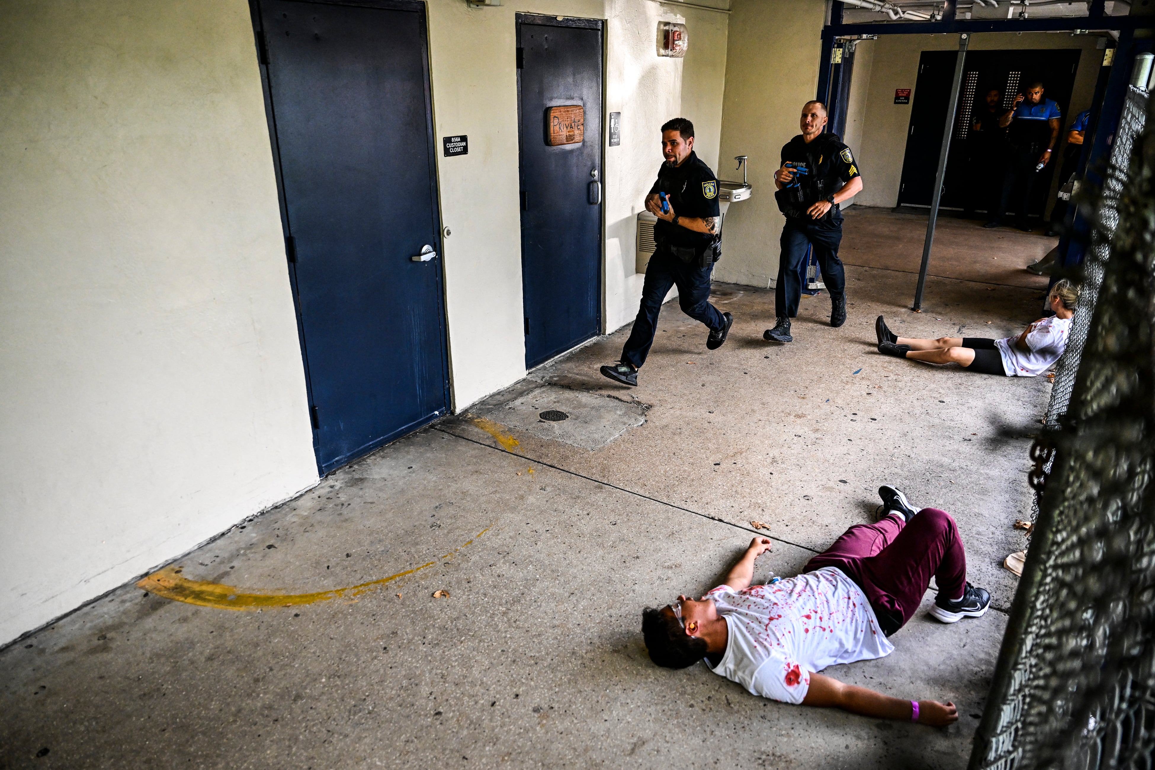 Los niños se hacen pasar por víctimas mientras los oficiales de policía de las escuelas de Miami-Dade realizan una operación de rescate mientras participan en un "simulacro de tirador activo funcional a gran escala" en Hialeah Senior High School en Hialeah, Florida, el 3 de agosto de 2022. (Foto de CHANDAN KHANNA / AFP)