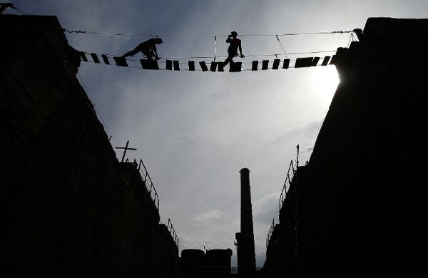 Miembros de un grupo de alpinismo alemán practican en un puente de una planta de acero en Duisburgo, Alemania. (AP) 