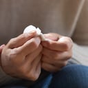 El primer plano de una mujer de mediana edad de 60 años sostiene un pañuelo de papel que se siente estresado, deprimido, melancólico por la pérdida, una hija cariñosa, reconfortante, caricia, una madre mayor triste, que muestra empatía y amor, un concepto de atención médica para personas mayores