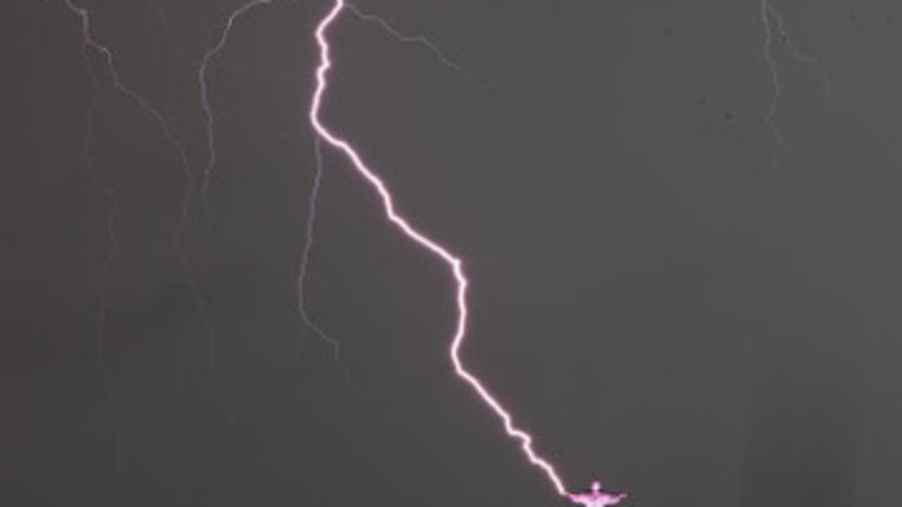 Vista de un rayo que cae en las manos de la estatua del Cristo Redentor, en la ciudad de Río de Janeiro (Brasil)