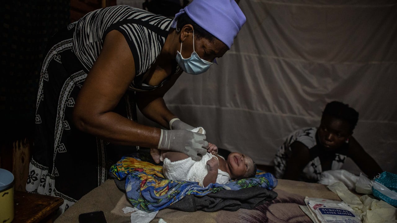 La partera Ivy Gatsi le pone un pañal de tela a una niña recién nacida que nació a primera hora de la mañana el 15 de enero de 2021.