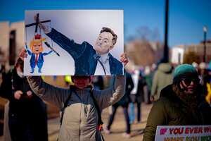 WASHINGTON, DC - FEBRUARY 17: A sign depicting Tesla and SpaceX CEO Elon Musk and U.S. President Donald Trump is visible as protesters rally against the Trump administration during "Not My President's Day" protests at the Capitol Reflecting Pool on February 17, 2025 in Washington, DC. Protests are being held in cities across the nation on Presidents' Day against what the organizers say are "the anti-democratic and illegal actions of the Trump administration." (Photo by Chip Somodevilla/Getty Images)