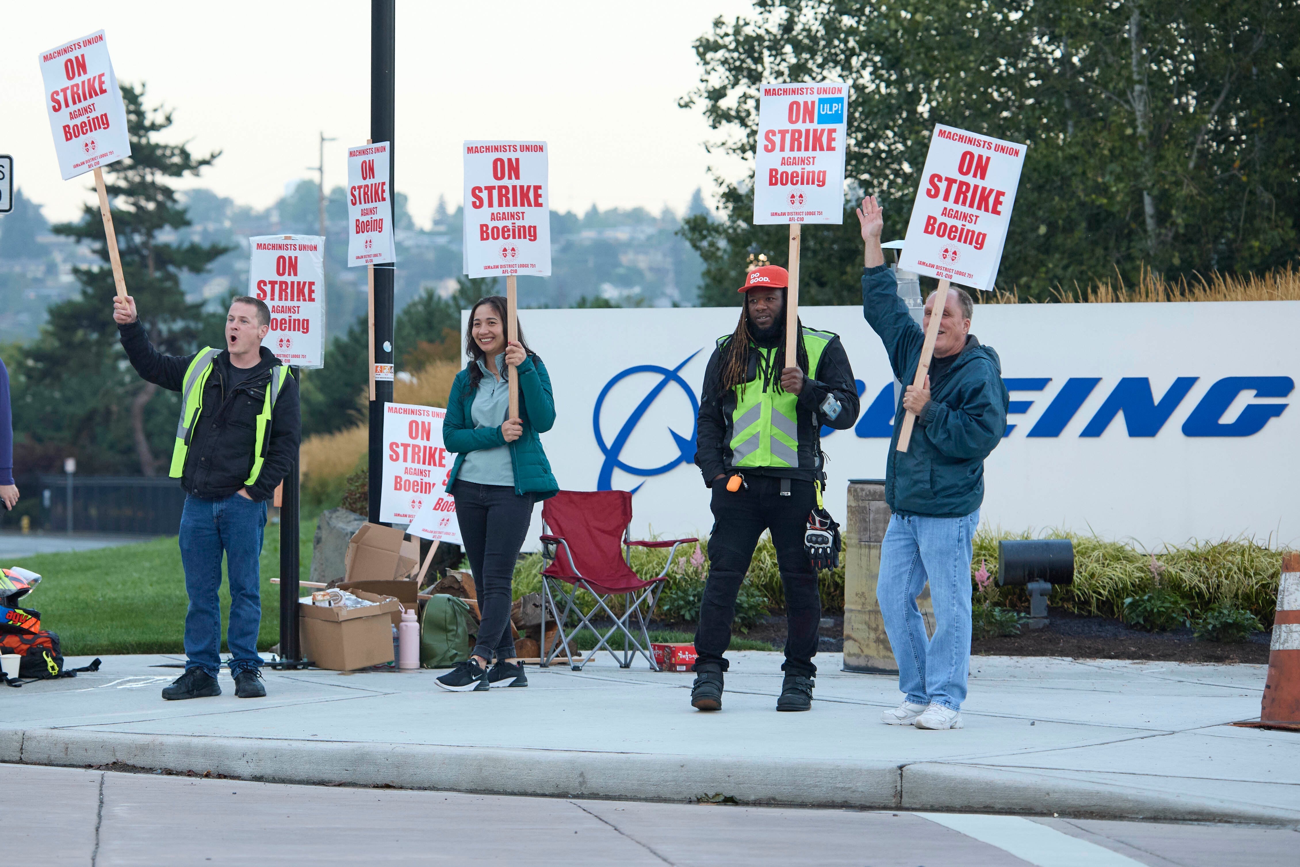 Los miembros del Sindicato de Maquinistas de Boeing desde la izquierda, Brent Roberts, Ha Nguyen, Myles Simms y Rich Russell, saludan al tráfico que pasa mientras están en el piquete en la planta de ensamblaje de Renton, el viernes 13 de septiembre de 2024, en Renton, Washington (Foto AP) /John Froschauer)