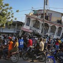 La gente se reúne fuera del Petit Pas Hotel, destruido por el terremoto en Les Cayes, Haití, sábado, 14 de agosto de 2021. Un terremoto de magnitud 7.2 golpeó a Haití el sábado, con el epicentro de unos 125 kilómetros (78 millas) al oeste de la capital de la capital de Port-au-Prince, dijo la encuesta geológica estadounidense. (AP Foto / Joseph Odelyn)
