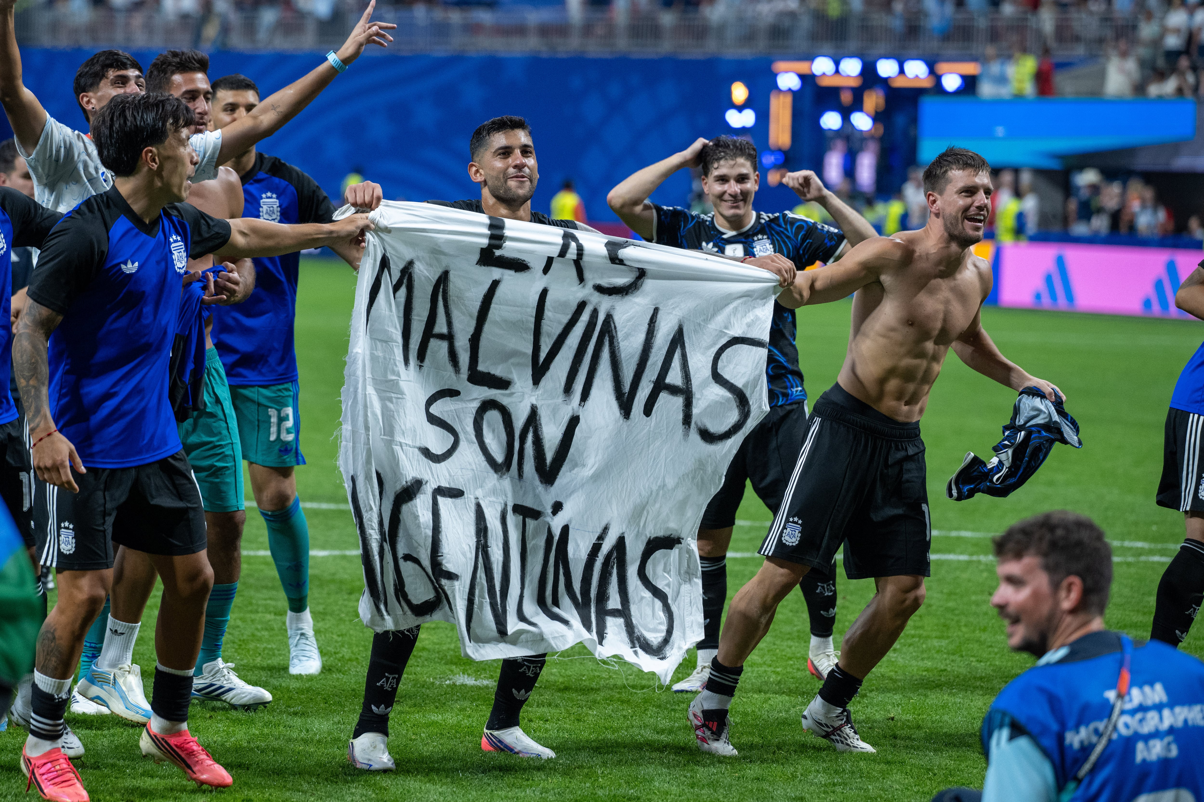 ATLANTA, GEORGIA - JULY 15: Lisandro Martinez, Cristian Romero, Giovani Lo Celso with a banner during the FIFA World Cup 2026 Semi Final match between England and Argentina at Atlanta Stadium on July 15, 2026 in Atlanta, Georgia. The banner refers to the British Overseas Territory of the Falkland Islands, located off the coast of Argentina. Argentina disputes British sovereignty over the islands and refers to them as Las Malvinas. (Photo by Sebastian Frej/Getty Images)