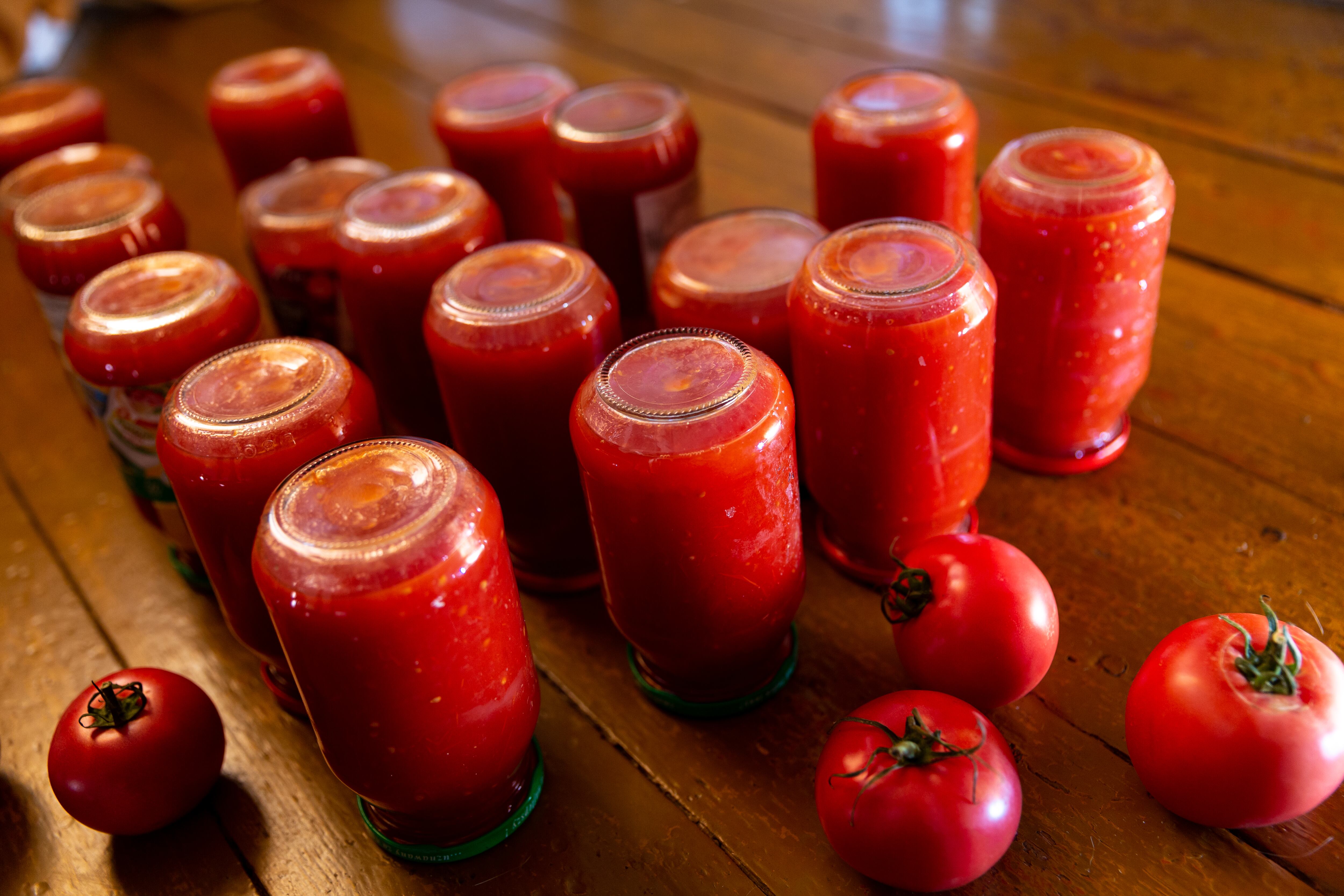 Puré de tomate casero y natural se enfría en frascos en una cocina