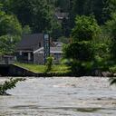 Un letrero que da la bienvenida a los visitantes al centro de Montpelier se ve detrás del río Winooski inundado el 11 de julio de 2023.