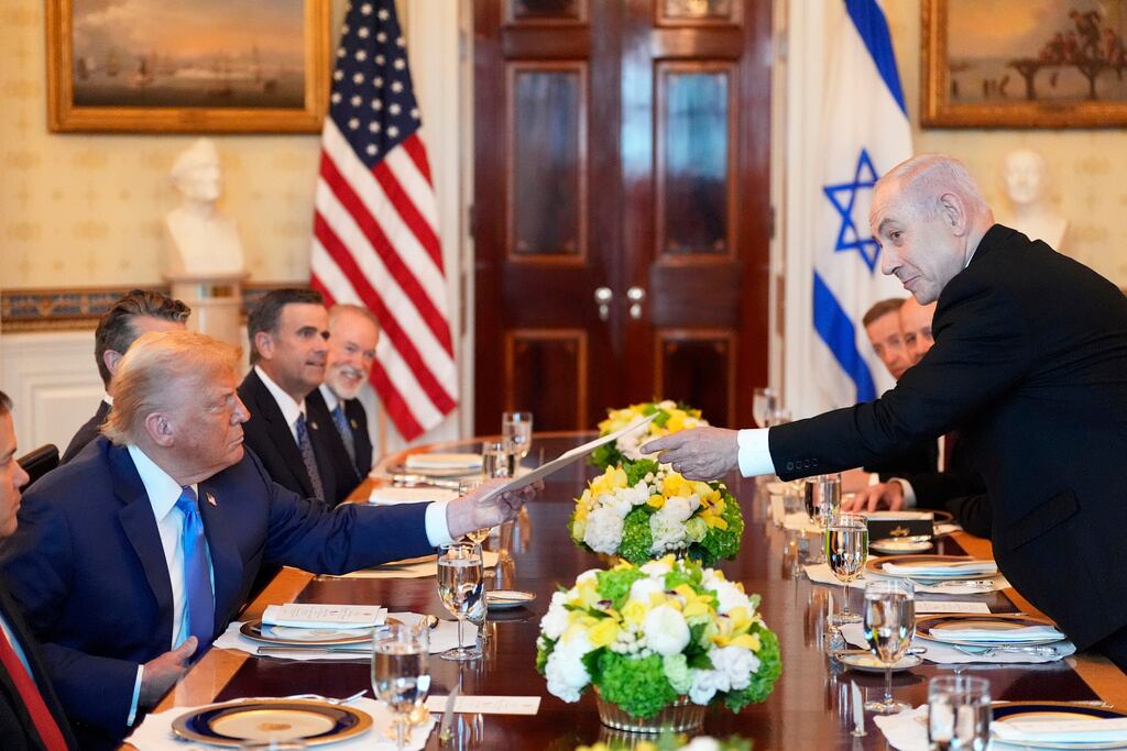 El primer ministro israelí, Benjamin Netanyahu (derecha), entrega una carpeta al presidente Donald Trump durante una reunión en la Sala Azul de la Casa Blanca, el lunes 7 de julio de 2025, en Washington.