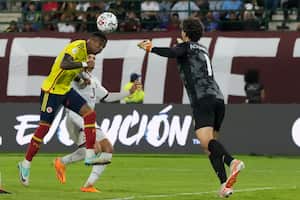 Colombia's Brayan Ceballos, left, heads the ball challenged by Venezuela's goalkeeper Samuel Rodríguez during South America's under-23 pre-Olympic tournament soccer match at Brigido Iriarte stadium in Caracas, Venezuela, Monday, Jan. 29, 2024. (AP Photo/Ariana Cubillos)